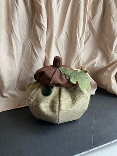 a small purse sitting on top of a table next to a white cloth covered curtain