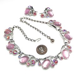 *Description: This is a beautiful Selro silver tone necklace and clip on earring set from the 1960s. Each piece has pink clear Lucite cabochons; accented with light pink rhinestones and aurora borealis hot pink rhinestones. It is a beautiful set and would be a great addition to your vintage jewelry collection or make a great vintage gift! *Approximate Measurements: Necklace Length - 17 1/2 Inches, Necklace Width - 3/4 Inch, Earrings Length & Width - 1 1/4 Inches, Total Weight - 2.1 Ounces *C Pink Rhinestone Costume Jewelry, Retro Pink Jewelry For Formal Occasions, Pink Retro Style Jewelry For Formal Occasions, Vintage Silver Jewelry Sets With Matching Earrings, Vintage Crystal Jewelry With Matching Earrings, Vintage Metal Jewelry Sets For Parties, Pink Costume Jewelry For Evening, Evening Pink Costume Jewelry, Pink Vintage Jewelry For Vintage Events