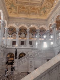 people are walking up and down the stairs in a large building with many windows on each side