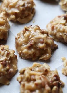 cookies with nuts are arranged on a sheet of wax paper, ready to be baked