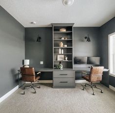 an office with two chairs and a desk in the corner, along with shelving units