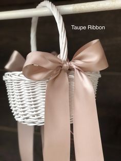 a white basket with a pink bow hanging from it