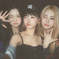 three girls posing for the camera with their fingers up