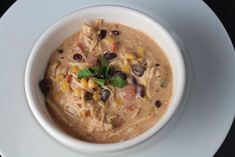 a white bowl filled with soup on top of a plate