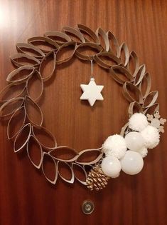 a christmas wreath made out of metal strips and plastic balls with a star hanging from it