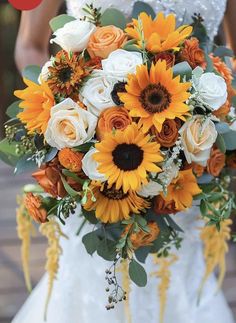 a bridal bouquet with sunflowers and roses in white, orange and yellow colors