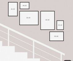 a set of stairs with white frames on the wall above them and below it is an area for numbers to be displayed