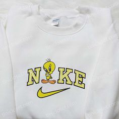 Introducing the Nike x Tweety Cartoon Embroidered Sweatshirt, a playful collaboration that combines the iconic Nike brand with the beloved Looney Tunes character, Tweety Bird. This sweatshirt features a high-quality embroidered design of Tweety on the front, adding a touch of nostalgia and charm to your wardrobe. The Disney Characters Embroidered T-shirt is a must-have [...] Nike Cartoon, Nightmare Before Christmas Hoodie, Nike Inspired, Dc Comics Shirts, Best Family Gifts, Kitty Accessories, Embroidered Shirts, Cartoon Embroidery, Beating Heart