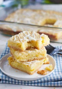 three pieces of cake sitting on top of a white plate next to a blue and white checkered napkin