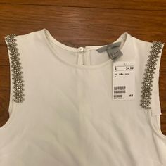 H And M Women’s Sleeveless Top With Silver Beading. Zip With Botton In Back And Dress Up Or Down. New With Tags Embellished Sleeveless Blouse For Summer, Embellished Sleeveless Tops For Spring, Sleeveless Embellished Tops For Spring, Embellished Sleeveless White Top, White Embellished Tank Top, White Embellished Sleeveless Tank Top, H&m Sleeveless Tank Top For Spring, Embellished Tank Top For Summer, Chic Sleeveless H&m Tank Top