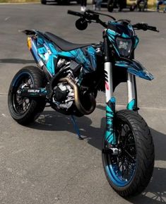 a blue and black dirt bike parked in a parking lot