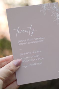 a person holding up a card with the word twenty written on it in white ink