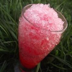 a glass filled with ice sitting in the grass