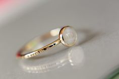 "This flash rainbow moonstone ring has a subtle, lux feel to it. I have set this 5mm round smooth rainbow moonstone gemstone into a solid 14kt yellow bezel cup with a thicker band ring. The 16 gauge solid 14kt yellow band has been also highly polished for a very reflective shine. This listing is for 1, 5mm rainbow moonstone ring. Material Information: Clarity: Occlusioned Color: rainbow Gemstone: moonstone Metal: 14kt yellow gold Handcrafted band: 16 gauge (1.4mm) faceted Please contact me with White Moonstone Stackable Ring With Round Band, Dainty White Moonstone Ring With Round Band, White Moonstone Stackable Rings For Promise, White Moonstone Stackable Rings, Stackable Opal Ring, Round Shape, Minimalist Moonstone Ring With Bezel Setting, Minimalist Round Moonstone Ring With Bezel Setting, Minimalist Round Moonstone Opal Ring, Gemstone Stacking Ring