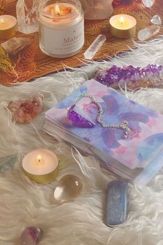 an assortment of crystals and candles on a blanket