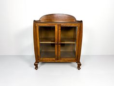 an old fashioned wooden cabinet with glass doors