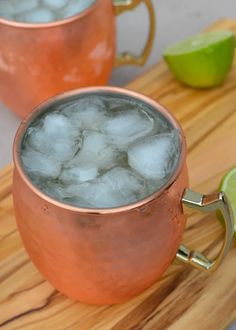 two copper mugs filled with ice and lime