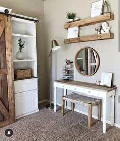 a white desk with a mirror and some shelves on top of it next to a wooden door