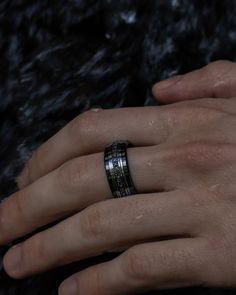 a person's hand with a ring on it