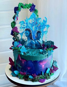 there is a cake decorated with blue frosting and flowers on the top of it