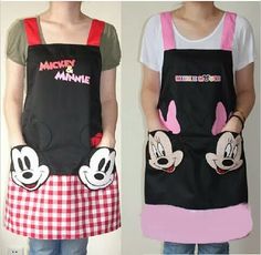 two people wearing aprons with mickey and minnie mouse designs on them, one in black and the other in pink