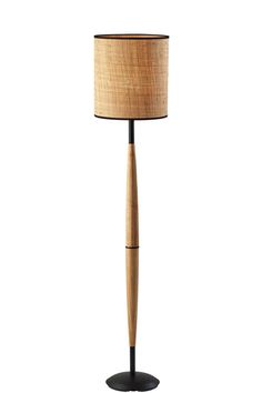 a wooden floor lamp with a black base and a light shade on the top of it