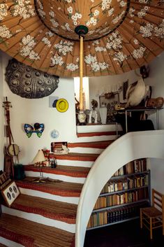 a room that has some books on the floor and stairs in front of it,