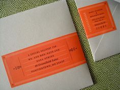 an orange and white ticket sitting on top of a green polka dot covered table cloth