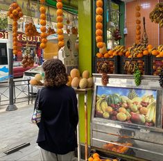 a woman standing in front of a fruit stand