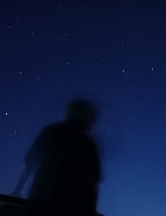 a man standing on top of a roof looking up at the stars in the sky