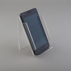 a cell phone in a clear case on top of a white table with a gray background