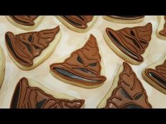 some cookies with chocolate icing on top of each one in the shape of a shoe