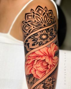 a woman's arm with flowers on it and an intricate design in the middle