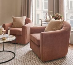 a living room with two chairs and a coffee table in front of a large window