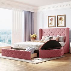 a bedroom with a pink bed and some pictures on the wall next to it in front of a window