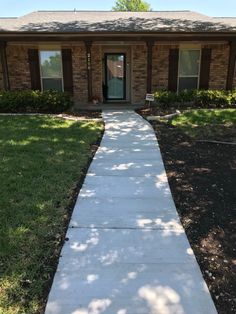 a sidewalk leading to a brick house