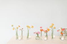 vases filled with flowers sitting on top of a white table next to each other