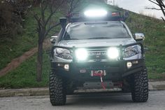 a silver truck with lights on driving down the road