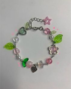 a bracelet with charms and hearts on it, including two butterflies in the shape of flowers