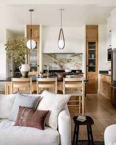 a living room filled with furniture next to a kitchen and dining room table in front of a stove top oven