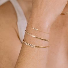 a woman wearing three bracelets with the word mama engraved on one side and two letters on the other