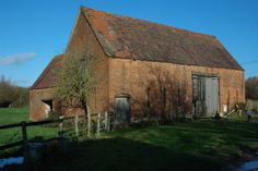 an old red brick barn in the country side