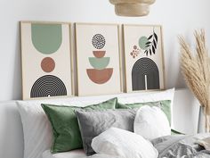 three framed art prints on the wall above a bed with white linens and pillows