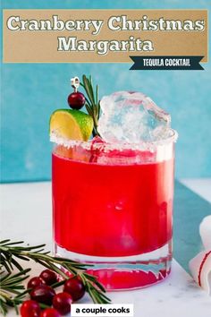 the cranberry christmas margarita is served in a glass with ice and garnish