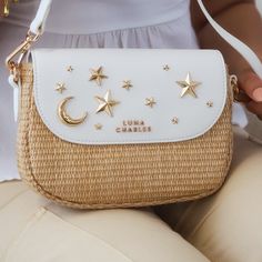 Starry Eyed for Summer Style ✨🌙 Be a real star with the Elena handbag! Crafted with natural rattan and vegan leather, it's adorned with glimmering gold moons and stars, it's the perfect accessory for those days when you want to shine. Keep your look stellar!  Vegan Leather & Natural Rattan Outer Vegan Suede Lining Detachable shoulder strap Gold hardware Concealed magnetic fastening  Inner zip pocket  Measurements - H: 16. 5cm  W: 22cm  D: 8cm Strap : 150cm max length (adjustable)  Sustainably Sourced Award winning luxury vegan leather Designed in the UK Vegan Leather & Natural Rattan Outer Vegan Suede Lining Rattan Handbags, Moons And Stars, Real Star, Starry Eyed, June Birthstone Jewelry, Zodiac Jewelry, Gifts For New Mums, Pearl Jewellery Earrings, Star Studs