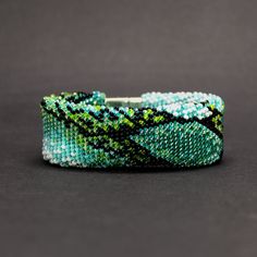 Beautiful emerald green snake bracelet with a python snakeskin pattern. This bead snake bracelet is made of Czech glass seed beads and a magnetic clasp. It is very flexible and comfortable to wear. This ouroboros bangle could be a lovely accessory for your look every day or on special occasions. It is easy, elegant, and modern jewelry. It is handmade, especially for you. The Feng Shui snake personifies wisdom and strength, energy and courage, knowledge and extraordinary intuition, and symbolizes Green Beaded Jubilee Bracelet, Unique Green Snake-shaped Jewelry, Green Beaded Bangle Bracelets With Spacer Beads, Green Beaded Bangle With Spacer Beads, Unique Green Beaded Bangle Bracelet, Ouroboros Bracelet, Bead Snake, Green Snake, Snakeskin Pattern