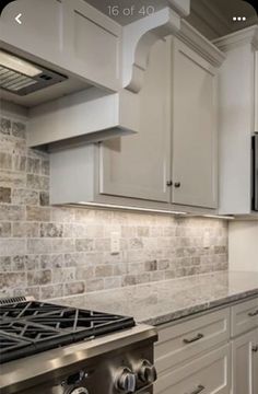 a stove top oven sitting inside of a kitchen next to white cabinets and counter tops