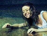 a woman laying on the ground with her arms spread out in the water and smiling