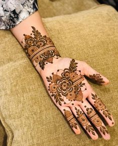 a woman's hand with henna tattoos on it