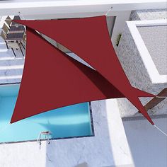 an overhead view of a red sail on the roof of a building with blue swimming pool